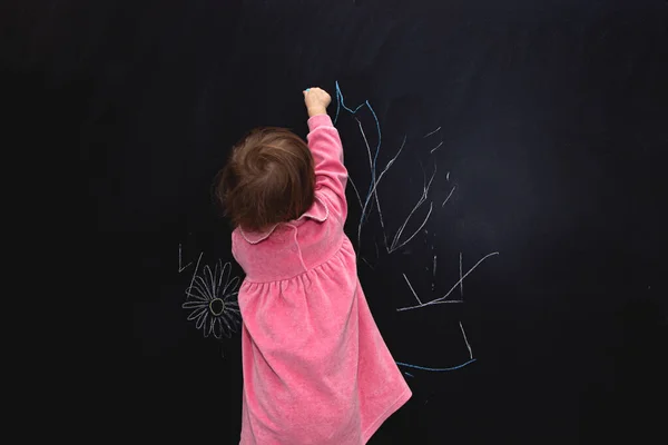 Милая Маленькая Девочка Пишет Розовым Мелом Доске — стоковое фото