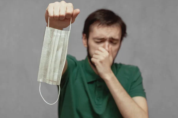 Een man weigert een medisch masker te dragen en niest — Stockfoto