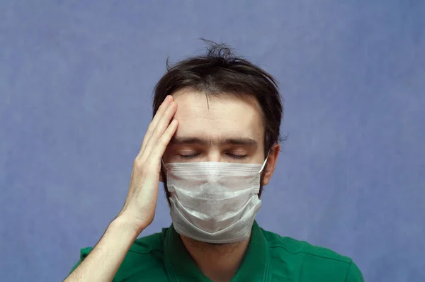 医療用マスクの男は片頭痛の種の頭を持ち — ストック写真