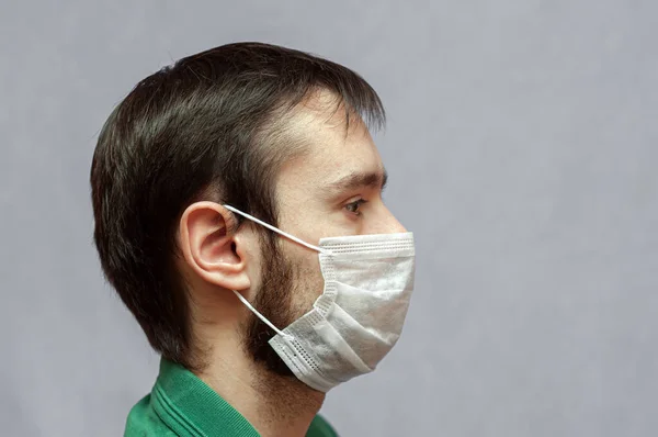 Profil bild av ung man bär ansikte medicinsk mask — Stockfoto