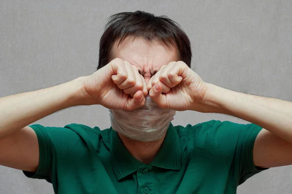 Hombre enmascarado se frota los ojos con las manos — Foto de Stock
