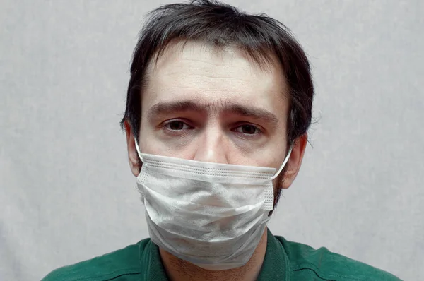 Nemocný muž v lékařské masce. smutné oči zavřít — Stock fotografie