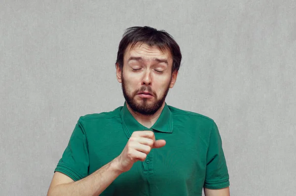 Hombre haciendo una cara divertida mientras tose en su mano — Foto de Stock