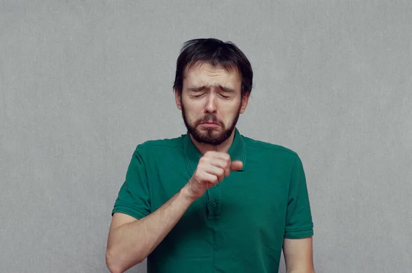 Hombre haciendo una cara divertida mientras tose en su mano — Foto de Stock