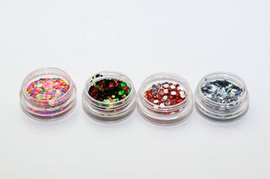 Küçük cam bir kavanozda manikür için yapay elmaslar. Jel tırnak tasarımı için malzemeler.