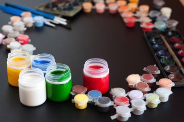 Renkli suluboya boya setleri, guaj, siyah arkaplanda boya fırçaları..