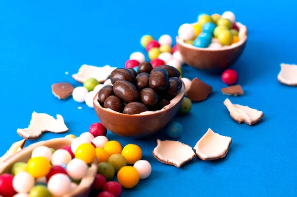 Deliciosos Ovos Páscoa Chocolate Quebrado Espalhar Doces Coloridos Fundo Azul — Fotografia de Stock