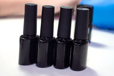 Bir grup tırnak jölesi siyah şişelerde parlıyor.