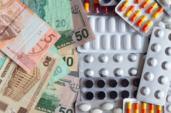 Medicinal different blister pills on the background of banknotes different currencies