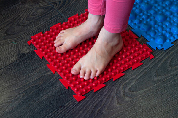 barefoot girl walks on colored sensory mats in the sensory integration room