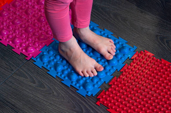 barefoot girl walks on colored sensory mats in the sensory integration room