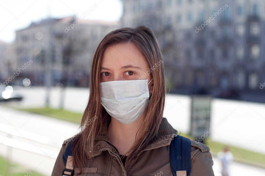 Woman in mask on street because of air pollution and epidemic in city. Protection against virus, infection, exhaust and industrial emissions