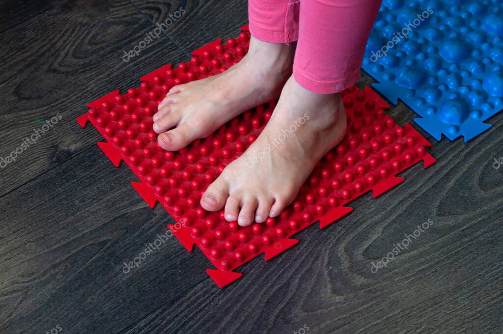 Barefoot girl walks on colored sensory mats in the sensory integration room