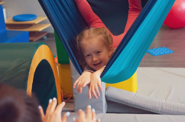 Cute Little Girl Enjoying Sensory Therapy Hammock While Her Physiotherapist — Stock Photo, Image
