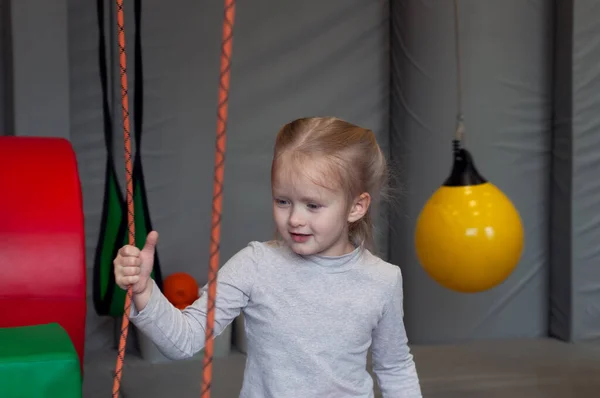 Smiling girl sitting in gym sensory integration on background — Stock Image Smiling Girl Sitting Gym Sensory Integration Background Stock Photo