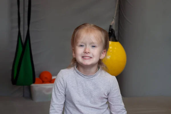 Smiling girl sitting in gym sensory integration on background — Stock Image Smiling Girl Sitting Gym Sensory Integration Background Royalty Free Stock Images