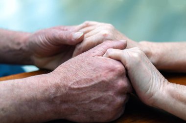 Yaşlı bir ailenin eski ellerini tutması. Yakın görüş, psikolojik destek konsepti, mutlu evliliğe güven.