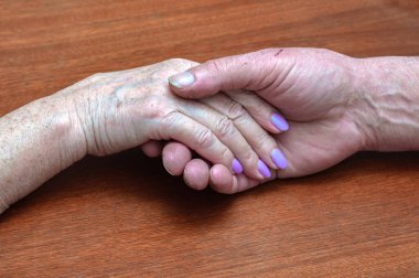 Yaşlı bir ailenin eski ellerini tutması. Yakın görüş, psikolojik destek konsepti, mutlu evliliğe güven.