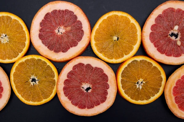 assorted of slice citrus and grapefruit fruits on black background close up