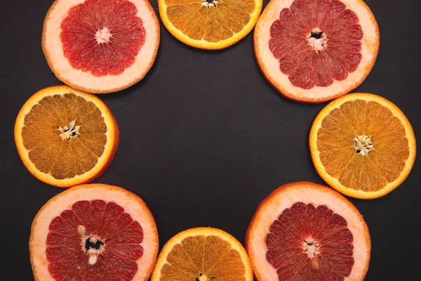 assorted of slice citrus and grapefruit fruits on black background close up