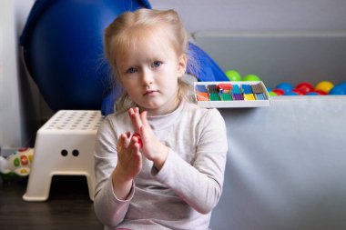 Küçük kız renkli modelleme kil, hamur ya da plastikle eğleniyor.