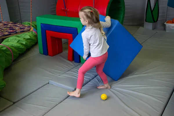Chica con un psicólogo juega en cubos suaves de colores. educación preescolar — Foto de Stock