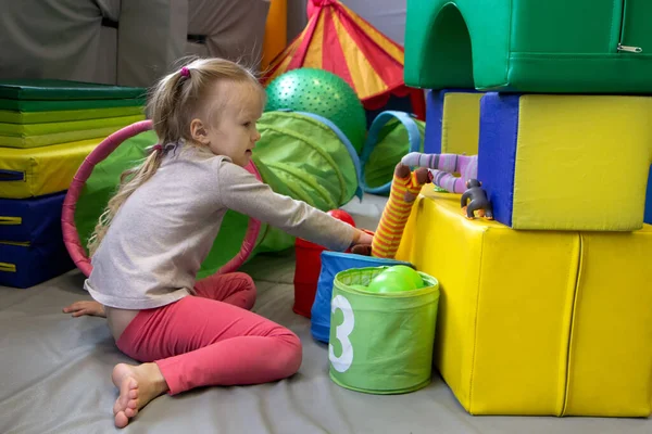 Chica con un psicólogo juega en cubos suaves de colores. educación preescolar — Foto de Stock