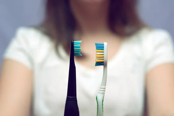 Γυναίκα Δείχνει Και Επιλέγοντας Μεταξύ Χειροκίνητων Και Ηλεκτρικών Οδοντόβουρτσες — Φωτογραφία Αρχείου