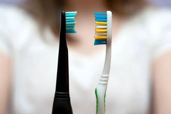 Kobieta Pokazując Wybierając Między Ręczne Elektryczne Szczoteczki Zębów Zbliżyć — Zdjęcie stockowe
