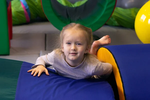 Smiling girl lies on the blue mat in gym sensory integration — Stock Image Smiling Girl Lies Blue Mat Gym Sensory Integration Stock Picture