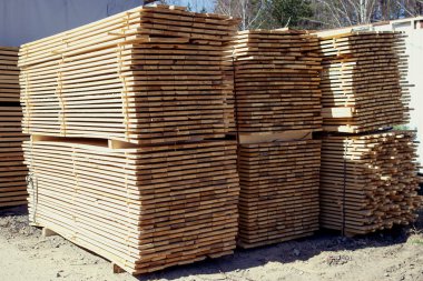 Kenar tahtalar satılmaya hazır. İnşaat malzemeleri deposu.