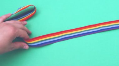 Erkek eli makaslı eşcinsel gururu kurdelesini kesiyor. LGBT toplumuna karşı saygısızlık ve ayrımcılık kavramı