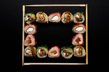 Siyah zemin üzerinde suşi ve çubuk olan çerçeve