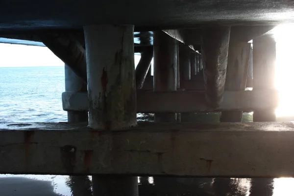 Pilones que llevan un muelle en el mar — Foto de Stock