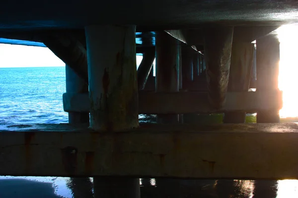 Pylonen met een pier op zee — Stockfoto