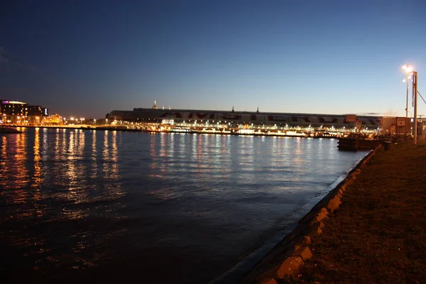 Panorama romantique du soir d'automne sur les eaux du canal de la ville métropolitaine néerlandaise d'Amsterdam, parmi les lumières et les illuminations des bâtiments et des gratte-ciel — Photo