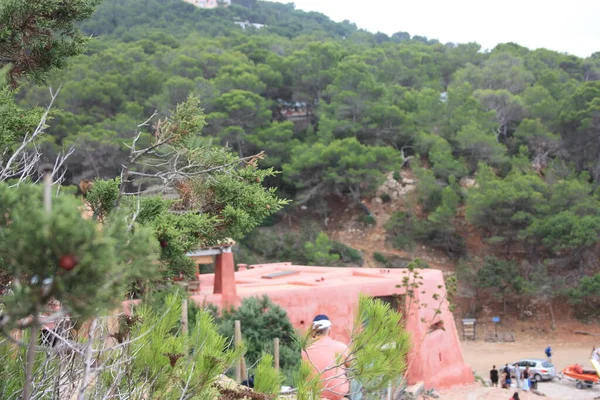 Piros ház épült a lejtőin egy zöld Ibizan hegy cala salada — Stock Fotó