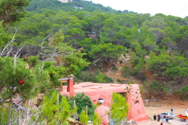 Rotes Ferienhaus an den Hängen eines grünen Ibizan-Hügels in Cala Salada — Stockfoto
