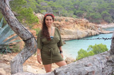Kafkasyalı kız Cala Saladeta 'in yamacında Balear adalarının vahşi doğasında yaz tatilinin tadını çıkarıyor.
