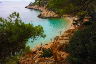 Ibiza 'nın güzel ve ünlü körfezi, kayalar ve balerinlerin bitki örtüsü arasındaki kayalık körfez ya da kayalık körfez.