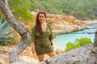 Kafkasyalı kız Cala Saladeta 'in yamacında Balear adalarının vahşi doğasında yaz tatilinin tadını çıkarıyor.