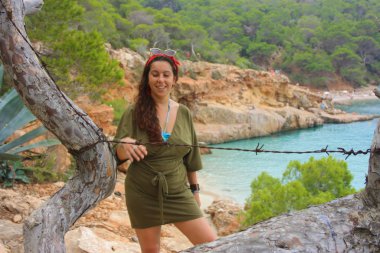 Kafkasyalı kız Cala Saladeta 'in yamacında Balear adalarının vahşi doğasında yaz tatilinin tadını çıkarıyor.