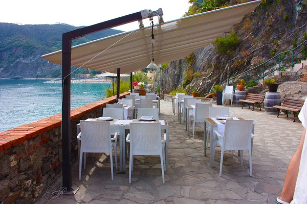 Um restaurante de luxo branco ou de cor clara, situado em mesas elegantes num terraço com vista para o mar, no Cinque Terre, em Monterosso — Fotografia de Stock