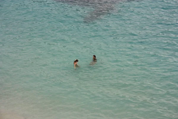 Two young brunettes bathe in the blue water of the sea — Stock Photo, Image