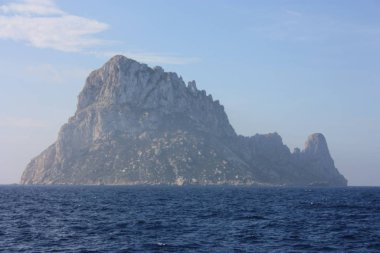 Es Vedra adası İbiza denizinin mavi sularındaki sisin arasında.