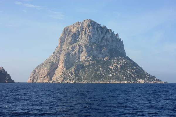 El islote de Es Vedra entre la niebla sobre el agua azul del mar ibiza — Foto de Stock