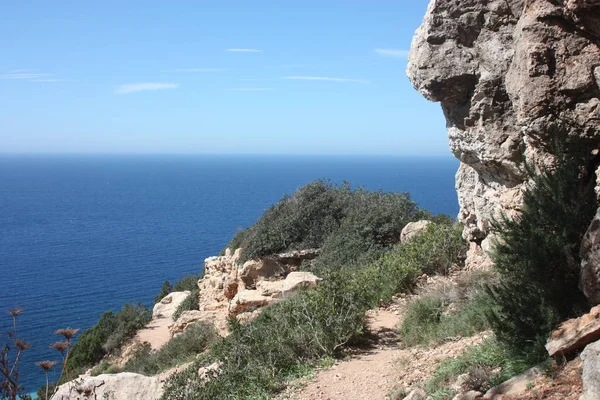 Panorama sobre el mar de jalá Cala D 'Hort entre los acantilados rocosos, rocosos y áridos frente al mar Ibiza azul casi caribeño —  Fotos de Stock