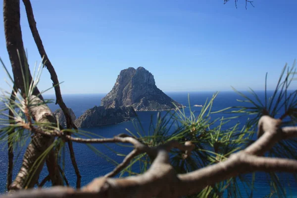 La mágica isla de Es Vedra con el pequeño islote de Es Vedranell junto a ella frente a la costa de Cala d 'Hort en la isla turística de Ibiza en medio de la naturaleza entre acantilados, playas y co —  Fotos de Stock