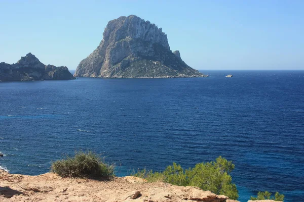 A ilha de Es Vedra entre o céu azul e o mar azul das costas Ibizan em frente à praia Cala D 'Hort nas Ilhas Baleares — Fotografia de Stock