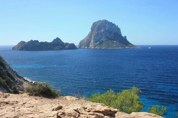 A ilha de Es Vedra entre o céu azul e o mar azul das costas Ibizan em frente à praia Cala D 'Hort nas Ilhas Baleares — Fotografia de Stock